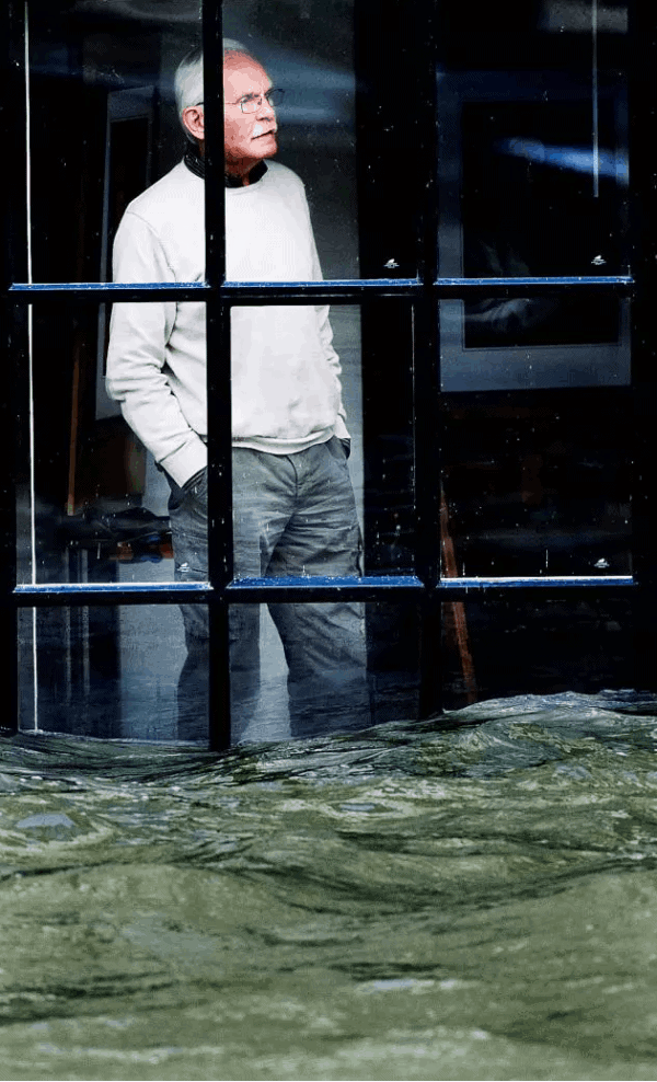 荷兰多德雷赫特市中心的凯斯·范勒斯先生透过窗户望着外面的洪水