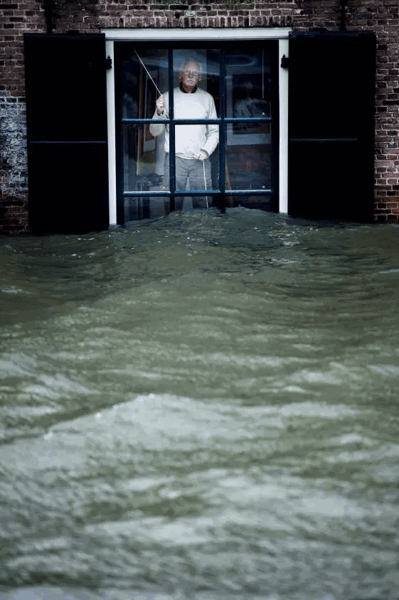 居住在荷兰多德雷赫特市中心的凯斯·范勒斯先生透过窗户望着外面的洪水