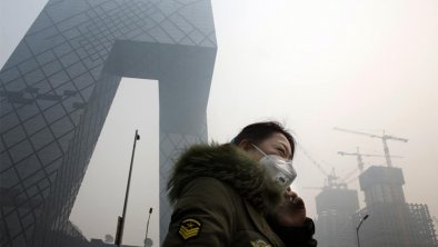 雾霾中的北京市民戴口罩和央视大楼