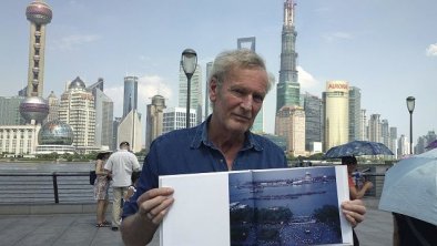 Robert van der Hilst站在上海外滩展示他的摄影作品